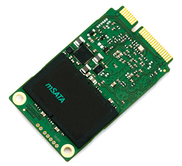 Foto eines mSATA-SSD-Laufwerks – kleine grüne Karte mit Flash-Chip und goldfarbenen Kontakten